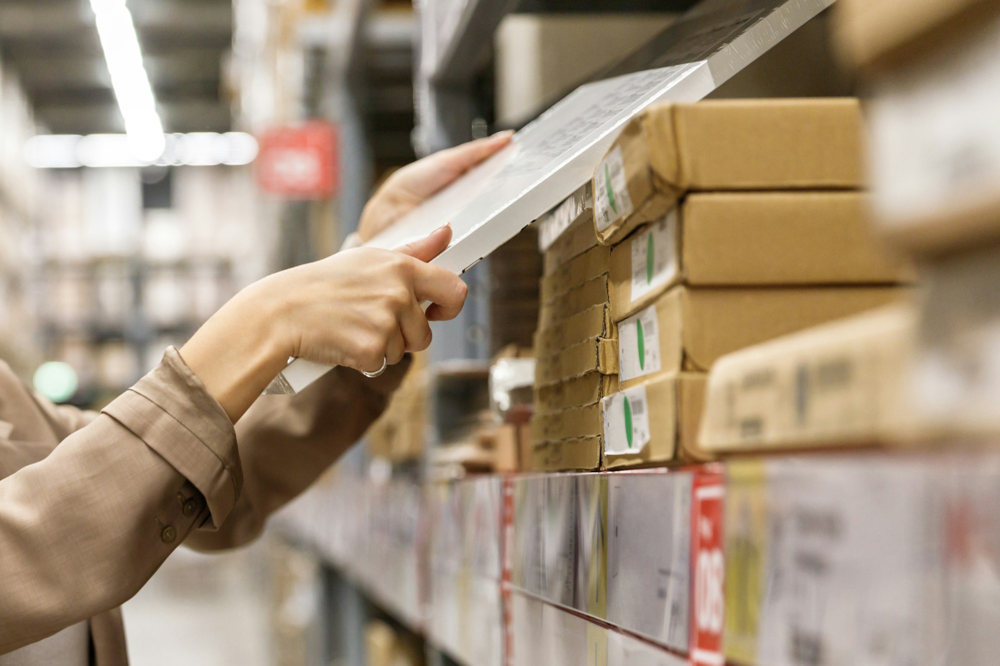 Close up of female customer picks up goods in store warehouse, side view. Shopping concept